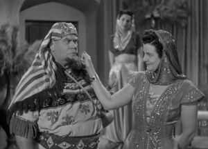 Vernon Dent getting his cheek pinched by the slave girl in the Three Stooges short, Mummy's Dummies