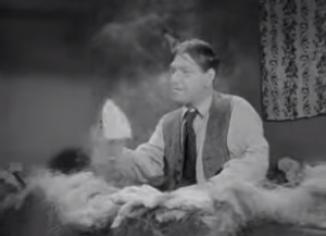 Shemp Howard in a bin full of stuffing, armed with a hot iron in Hugs and Mugs - Three Stooges short film