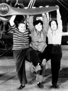 Dizzy Pilots - publicity photo showing Curly, Moe and Larry trying to start the engine of their experimental plane, The Buzzard