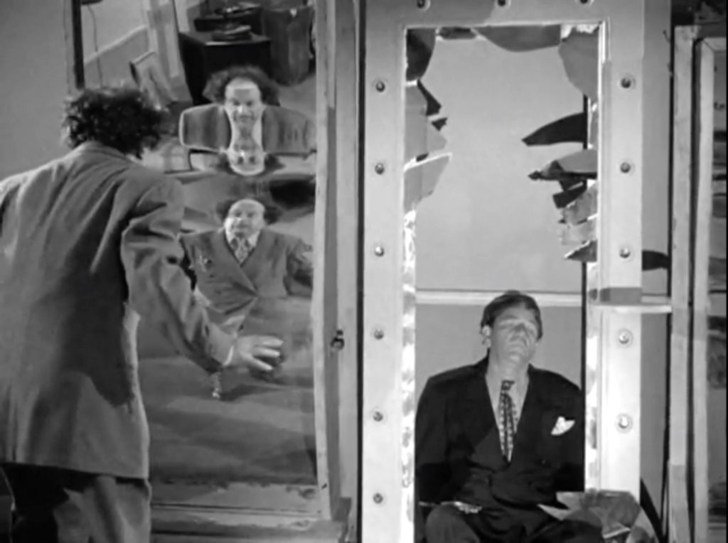 Shemp Howard accidentally breaks one of the funhouse mirrors, while Moe and Larry play with them