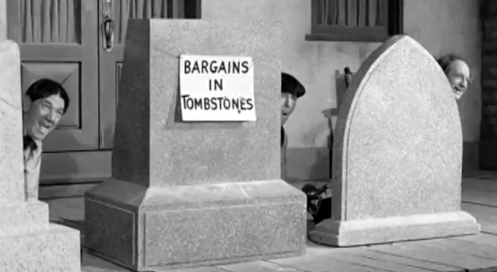 Shemp, Moe, and Larry hiding behind tombstones in "Shot in the Frontier"