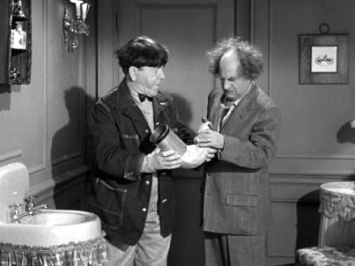 Moe Howard and Larry Fine looking for the ring in a pipe in "Scheming Schemers"
