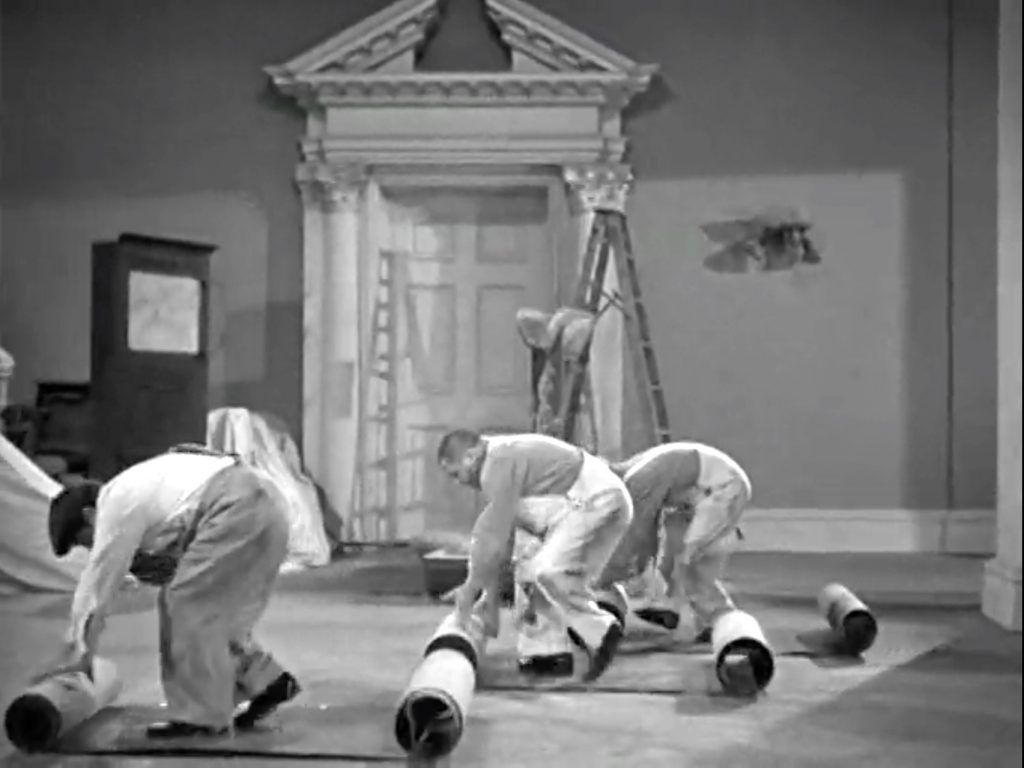 Moe Howard, Larry Fine, Curly Howard rolling out the carpet