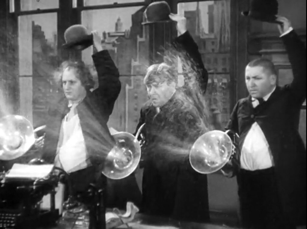 The Three Stooges (Moe, Larry, Curly) squirting Ted Healy in "The Big Idea"